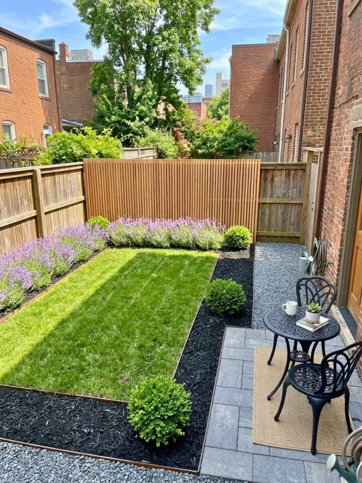 small yard landscaping with black mulch and compact plants